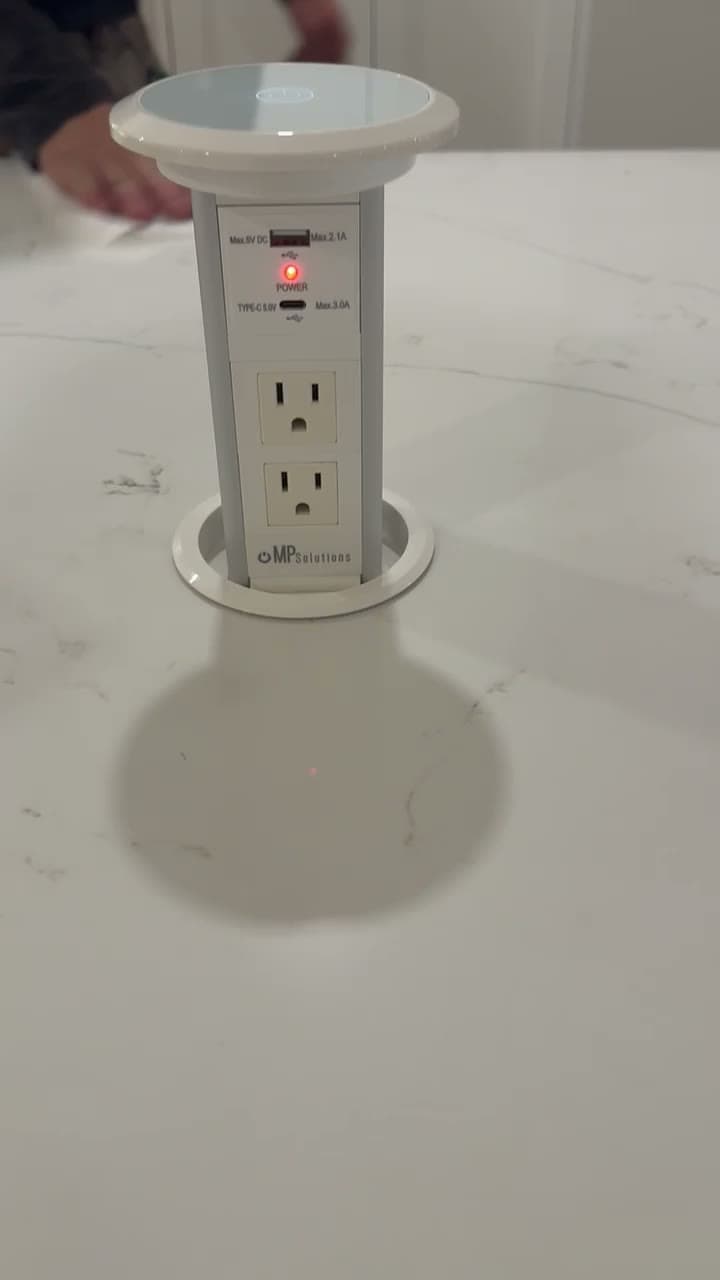 MP Solutions pop-up power tower extended from a marble countertop, with USB-A, USB-C, and two outlets